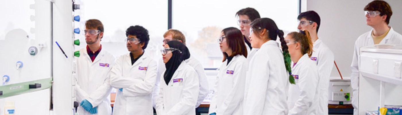 Chemistry students in lab coats and goggles