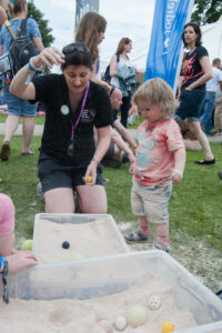 Sarah showing a child an experiment at Bluedot Festival