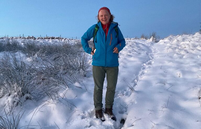 Katherine Morris stand on a snowy track and smiles at the camera.