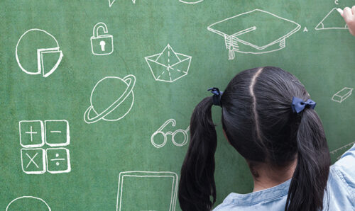 Young girl sketching on a blackboard