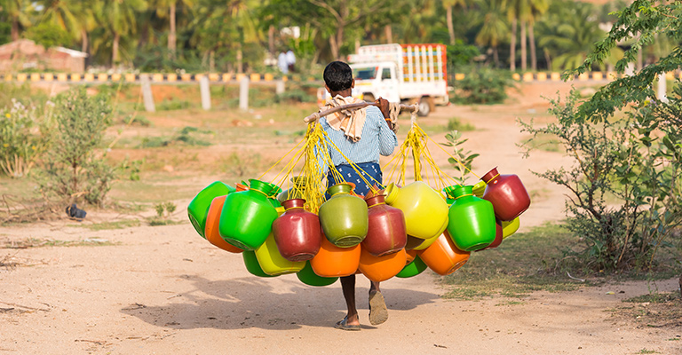 Man carrying colourful water tubs