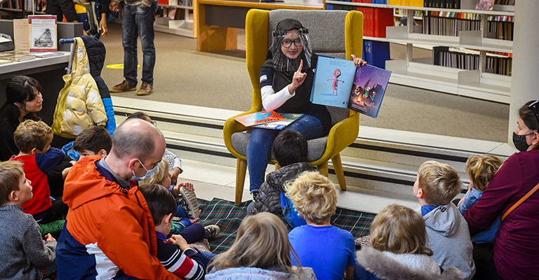 Adult volunteer reads to children